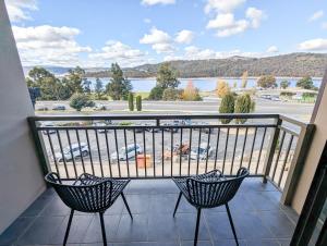 a balcony with two chairs and a view of a parking lot at Jasper 3 in Jindabyne