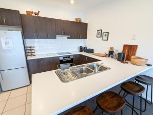a kitchen with a sink and a counter with stools at Jasper 3 in Jindabyne