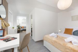 a white bedroom with a bed and a desk and a table at Villa Marica Tiny House in Krk city centre in Krk