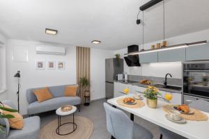 eine Küche und ein Wohnzimmer mit einem Tisch und Stühlen in der Unterkunft Villa Marica Tiny House in Krk city centre in Krk