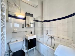Un baño blanco con lavabo y bañera. en Le Notre Dame, Studio à 400m des Arènes de Nîmes, en Nimes