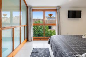 a bedroom with a bed and a large window at Loft El Til-ler in Bellvei del Penedes