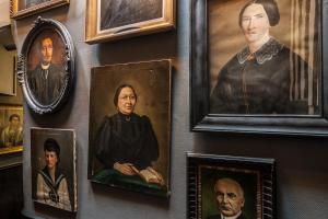 Un mur avec des portraits et des portraits de personnes qui s'y trouvent dans l'établissement Le 84 Sainte-Cath', à Lille