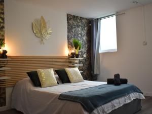 a bedroom with a bed with a wooden headboard at LE CONCORDE-WIFI-Clim-Parking-3étoiles-OcKeys in Bram