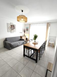 ein Wohnzimmer mit einem Tisch und einem Sofa in der Unterkunft Gasperi in Brive-la-Gaillarde