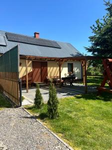 - un pavillon avec une table de pique-nique en face d'un bâtiment dans l'établissement Domek Zuza Nielisz, à Nielisz