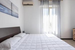 um quarto com uma grande cama branca e uma janela em 22 Passi dal mare( Parcheggio privato + wifi) em Francavilla al Mare