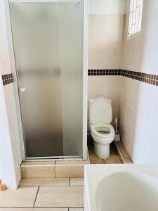 a bathroom with a toilet and a glass shower at Frere Hill Guesthouse in Durban