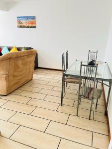 a dining room with a glass table and chairs at Frere Hill Guesthouse in Durban