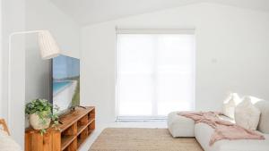 a living room with a tv and a couch at Bungalow 21 in Callala Beach +17 photos