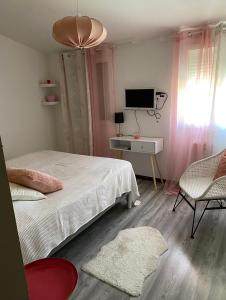 Un dormitorio con una cama y un escritorio con televisión. en Chambre chez l habitant à 200 m du bord de mer, en Port-de-Bouc