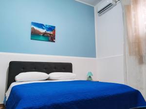 1 dormitorio azul con 1 cama con manta azul en Affitto camere Mazara da Baldo vicino ospedale Abele Ajello, en Mazara del Vallo