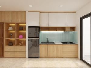 La cuisine est équipée d'armoires en bois et d'un réfrigérateur en acier inoxydable. dans l'établissement Dinh’s Aparment, à Tuy Hoa