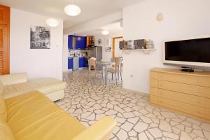 a living room with a couch and a flat screen tv at Apartments Mel in Bol