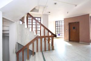 - un escalier dans un bâtiment avec une porte en bois dans l'établissement Capital O Hotel Kartik, à Jabalpur
