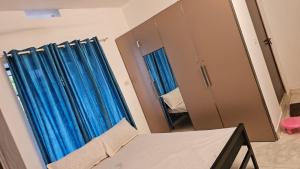 um quarto com cortinas azuis e um espelho em Peaceful homes em Thrissur