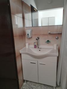 een badkamer met een witte wastafel en een spiegel bij Apartman Temais in Duga Resa