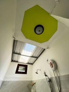 uma casa de banho com um tecto verde e uma janela em Urban Galle Villa em Galle