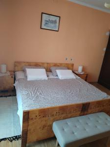 een slaapkamer met een houten bed met 2 kussens bij Apartman Temais in Duga Resa