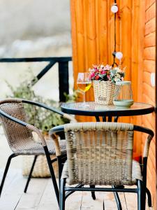einen Terrassentisch mit 2 Gläsern Wein und Blumen in der Unterkunft Cozy chalet in Mestia in Mestia