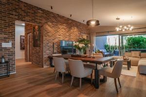 a dining room with a brick wall and a table and chairs at STING Residence Platan in Ostrava