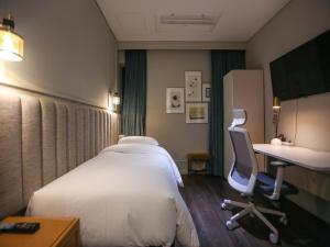 a hotel room with a bed and a desk at Hotel Crescendo Seoul in Seoul