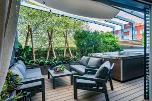 a patio with a hot tub and chairs and a table at STING Residence Platan in Ostrava