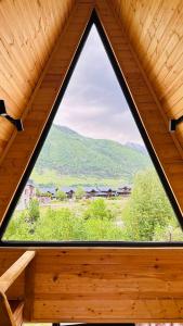 a window in a wooden cabin with a view at Cozy chalet in Mestia in Mestia