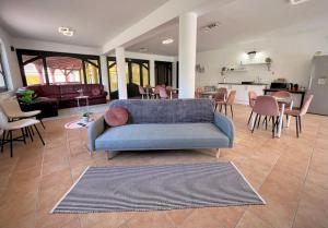 a living room with a blue couch and a kitchen at Nussbaum Panzió in Keszthely