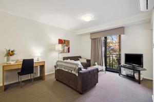 a living room with a couch and a television at Urban Serenity 2 Bedroom Apt with Stunning Views in Perth