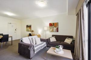 a living room with a couch and a bed at Urban Serenity 2 Bedroom Apt with Stunning Views in Perth