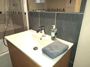 a bathroom sink with a towel and a shower at Suite Chanzy 69 in Reims