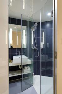 a bathroom with a glass shower with a sink at Great Gravity Hotel in Durban