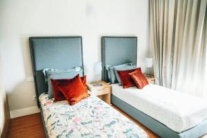 two beds in a room with red pillows at Great Gravity Hotel in Durban