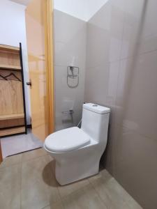 La salle de bains est pourvue de toilettes blanches. dans l'établissement E&R Airport Hotel, à Dumaguete