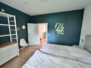 sypialnia z białym łóżkiem i zieloną ścianą w obiekcie RaumtoGo No1 Modernes Ruhiges 2-Schlafzimmer Apartment in Wiesbaden City & Park w mieście Wiesbaden