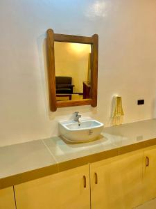 a bathroom with a sink and a mirror at E&R Airport Hotel in Dumaguete