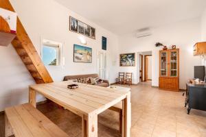 a living room with a wooden table and a staircase at Casa Es Vedrà in Cala Saona