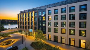 an office building with a sunset in the background at Hey Lou Hotel Monheim am Rhein in Monheim