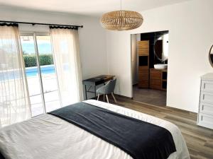 Schlafzimmer mit einem Bett, einem Schreibtisch und einem Fenster in der Unterkunft Villa avec piscine et jacuzzi 3 min mer in Grosseto-Prugna