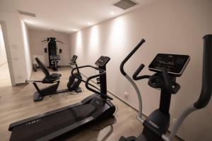 a gym with three exercise bikes and a treadmill at Lorry Living Luxury, Bohemian Apartment in Cavaion Veronese
