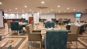 a restaurant with tables and chairs in a room at Seven Hills Hotel in Puri