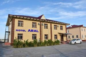 un gran edificio de madera con un coche aparcado delante en Aral, en Nukus