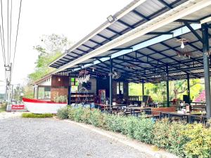 ein Gebäude mit Tischen und einem Boot darauf in der Unterkunft Khum Khun Phon Resort Khao Yai in Nong Nam Daeng
