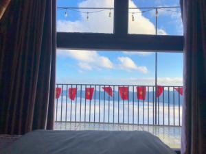 ventana de un dormitorio con vistas al océano en Mây House – Sống Lưng Khủng Long en Bắc Yên