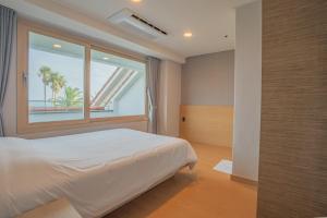 a bedroom with a bed and a large window at Seaore Resort in Seogwipo