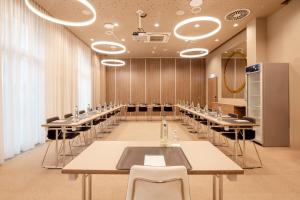 une salle de conférence avec de longues tables et chaises dans l'établissement Hey Lou Hotel Monheim am Rhein, à Monheim