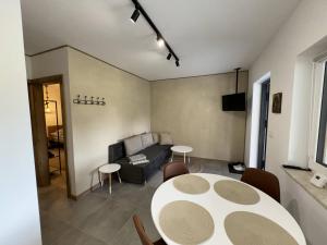 a living room with a table and a couch at Apart Home Bieszczady in Uherce Mineralne (7)