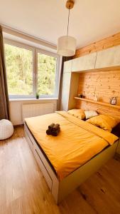 una camera da letto con un grande letto con un orsacchiotto sopra di #Apt23 - Apartmán 23 - Novohradské hory a Benešov nad Černou