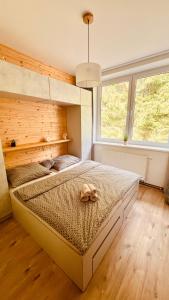 una camera da letto con un letto e un animale di peluche di #Apt23 - Apartmán 23 - Novohradské hory a Benešov nad Černou